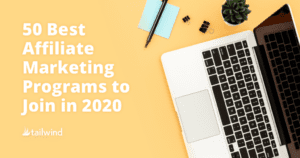 A laptop, pen, sticky notes, binder clips, and a small potted plant on a yellow desk with text: "50 best affiliate marketing programs to join in 2020. tailwind.