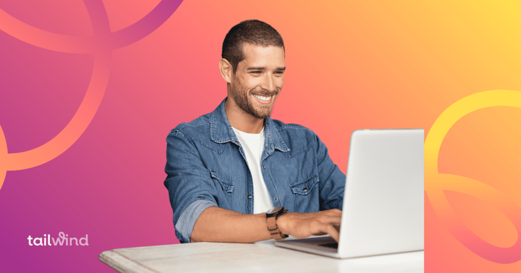 Man smiling and working on a laptop