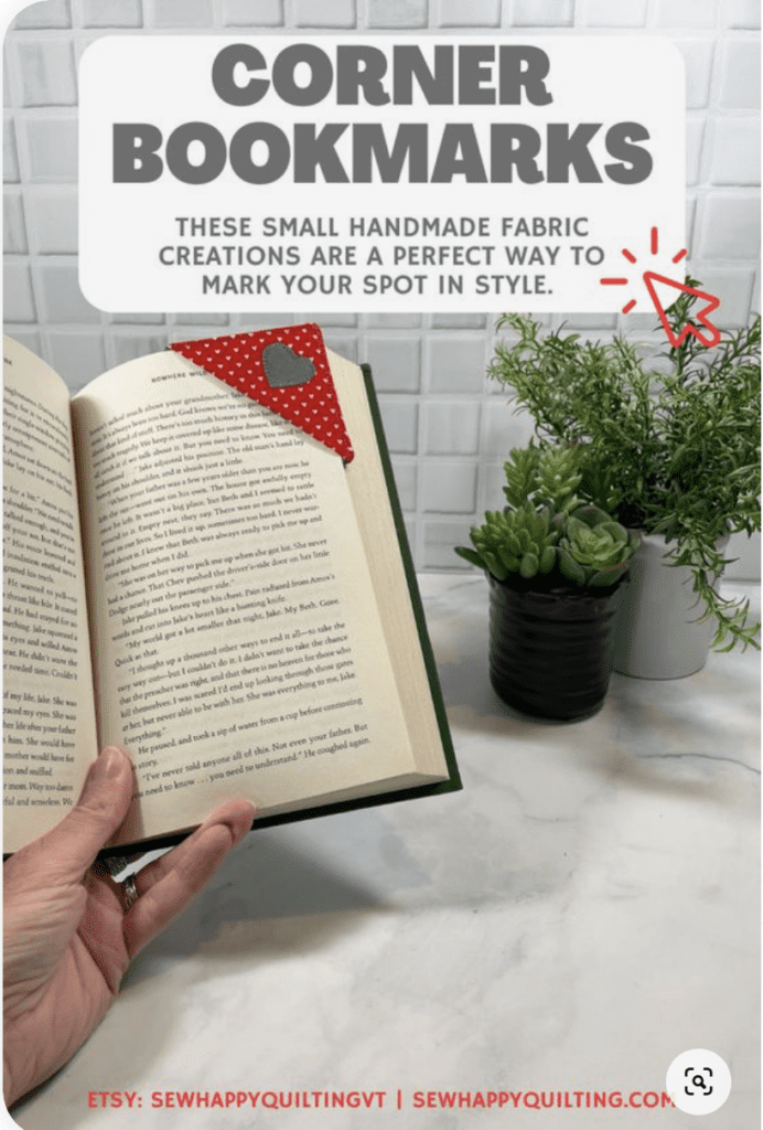 Screenshot of a pin from Sew Happy Quilting.com showing a photo of a hand holding a book open with a corner bookmark on the page. Text on the pin says: Corner Bookmarks these small handmade fabric creations are a perfect way to mark your spot in style.