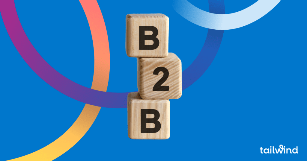 Image of wooden toy blocks stacked on each other with B 2 B stamped on them on a blue background with the  tailwind logo in white font.